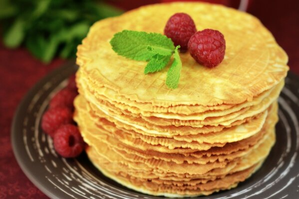 A stack of waffles with raspberries