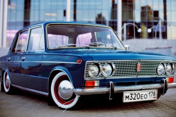 Low classic Lada vaz blue at the building with large glass windows