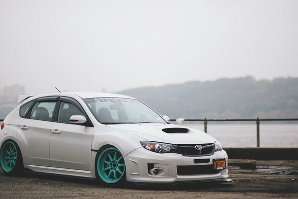 Subaru Impreza blanco con Llantas de color turquesa