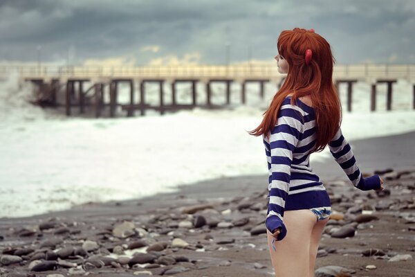 Dreaming red-haired girl on the pier