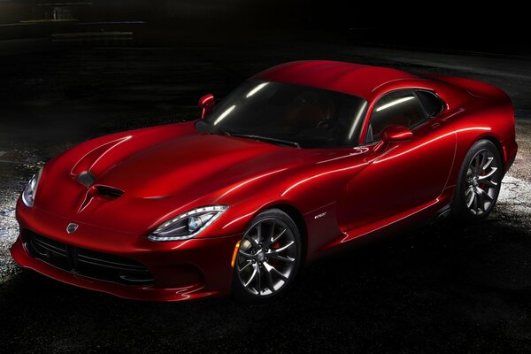 Red Dodge on wet asphalt in semi-darkness