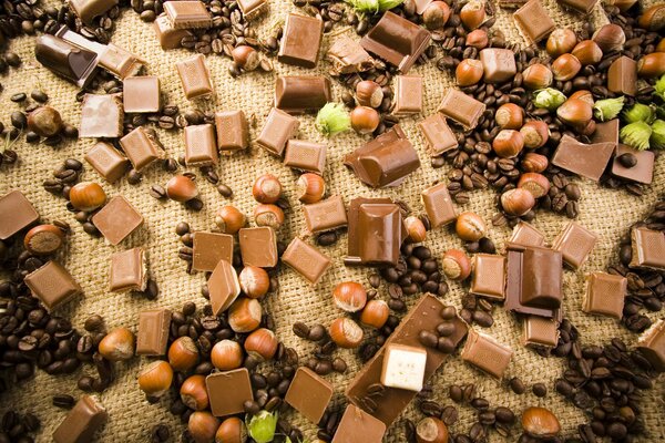Nuts, coffee beans and chocolate scattered on the fabric