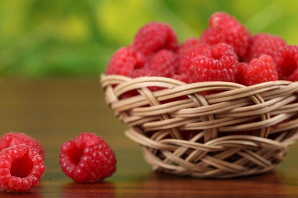 Himbeeren in einer geflochtenen Vase auf dem Tisch