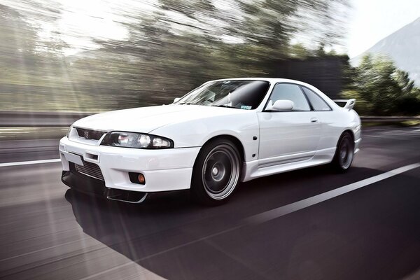 A white car rides through the sun s rays