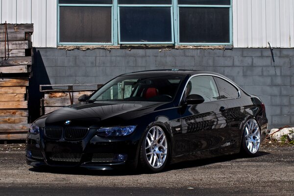 BMW negro y pared gris con ventanas