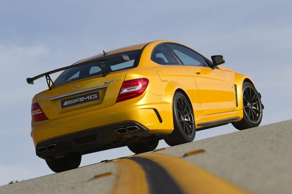 Une mercedes-benz AMG jaune brise un double solide sur la piste