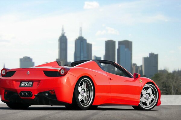 Red tuned Ferrari on the background of the city