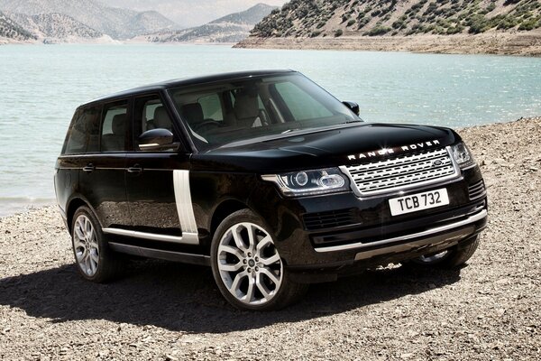 La voiture Land Rover se tient devant le lac