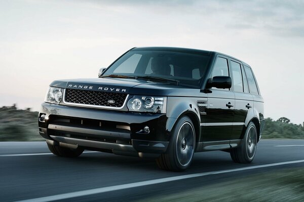 Спортивный черный джип land rover на дороге