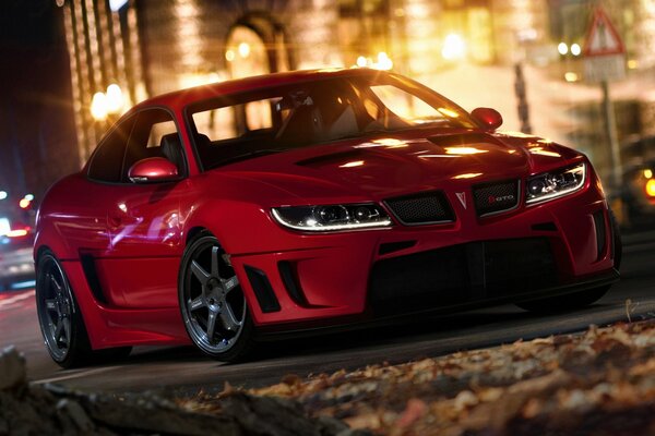 Pontiac rojo en la ciudad de la noche