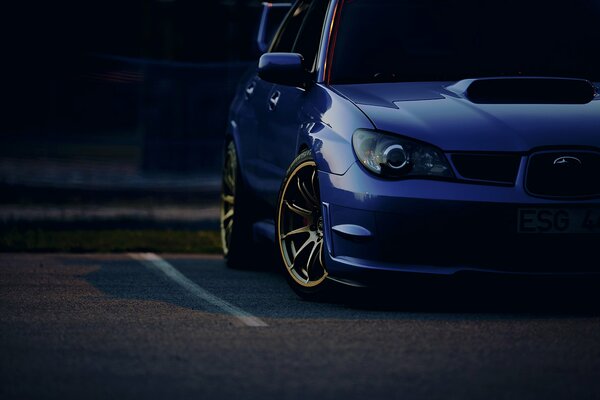 Blauer Subaru am Abend auf dem Parkplatz