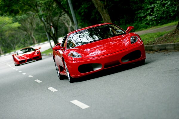 The red Ferrari is racing down the road in the heat