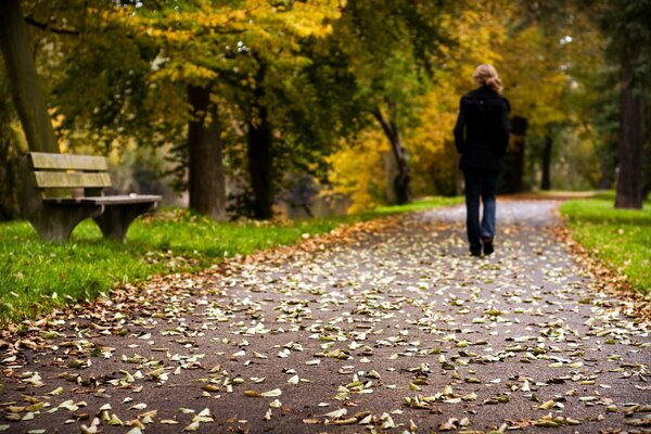 Chica caminando en el parque de otoño