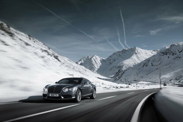Guida la Bentley Continental attraverso le montagne innevate