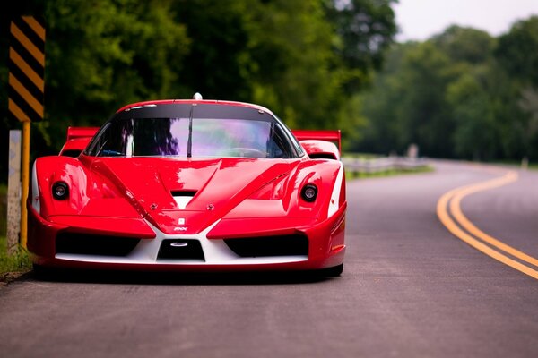 Czerwone Ferrari przy plakietce drogowej