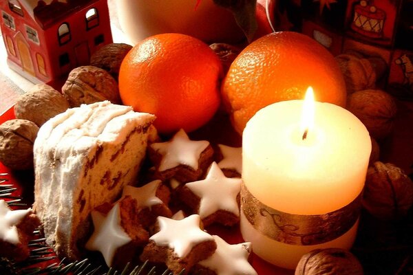 Weihnachtskuchen, Orangen und Kerzen