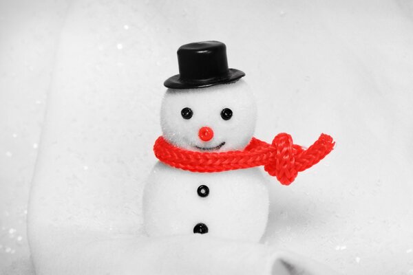 A snowman with a red scarf and a black tselindra