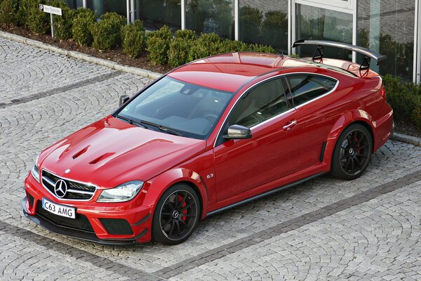 Mercedes S63 rojo al lado del edificio de lujo