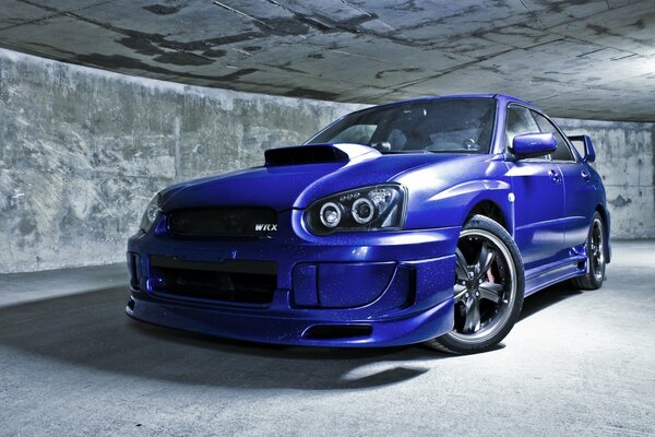 Blue Subaru sports sedan on a concrete background