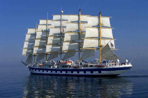 A ship with white sails on the sea