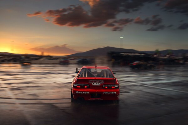 A red sports car in the light of a crimson sunset