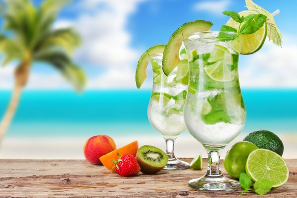 Cocktail with lime and avocado on the background of the beach