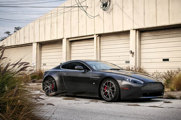 Samochód Aston Martin na tle garaży