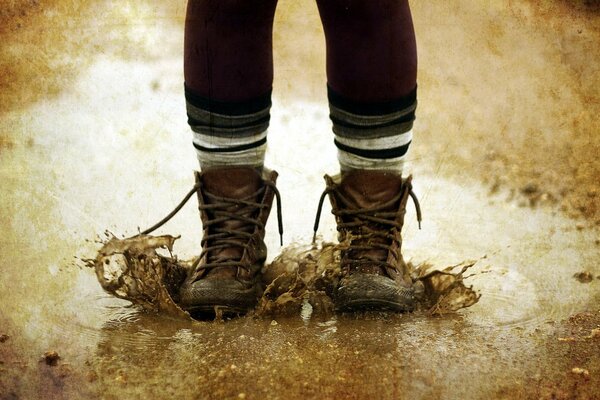 I piedi di un bambino che è saltato in una pozzanghera