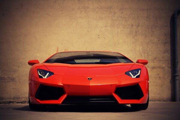 El Lamborghini aventador rojo se encuentra en el fondo de la pared