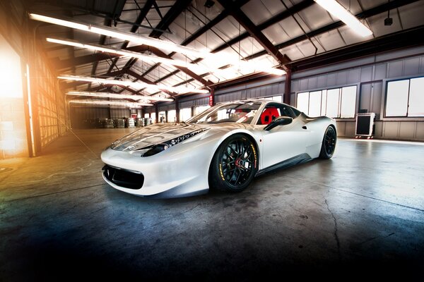 Auto sportiva bianca in piedi in un hangar