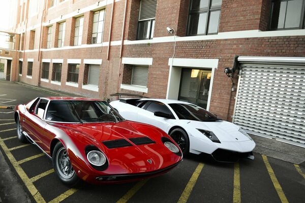 Lamborghini et murcielago se trouvent à proximité sur le parking près de la maison