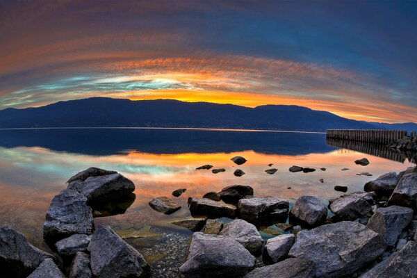 Sunset in the evening on the lake with rocks