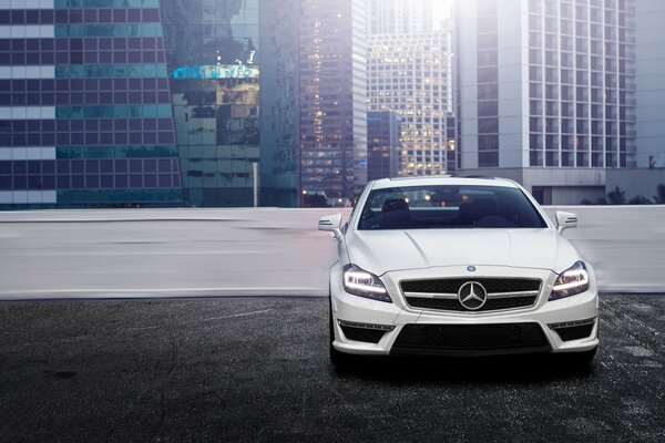 Mercedes benz cls dans le parking de la ville devant les bâtiments