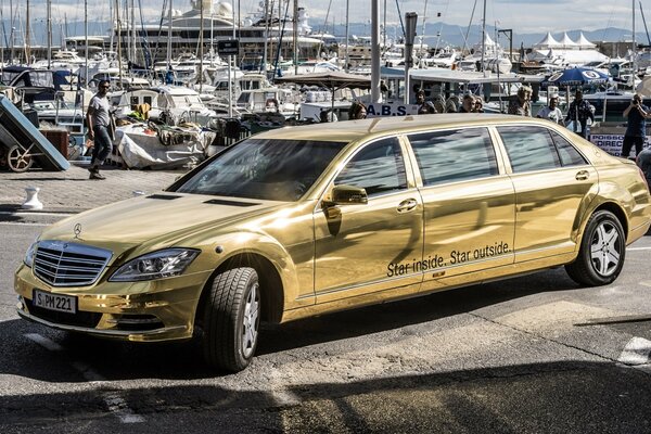 Złoty metalowy samochód Mercedes Benz na komisie samochodowym