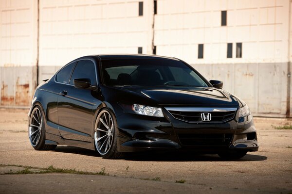 Honda noir se dresse sur le béton sur le fond d un bâtiment blanc