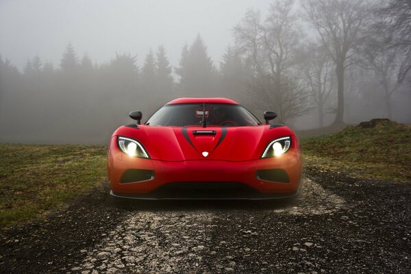 Hypercar rosso koenigsegg nella foresta