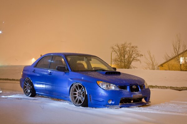 El coche azul de Subaru en la nieve