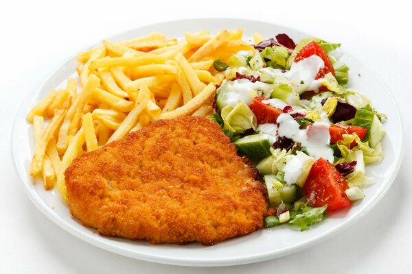 Mittagessen auf einem Teller - Schnitzel, Pommes Frites und Salat