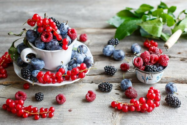 A mug with a berry on the table is black and red