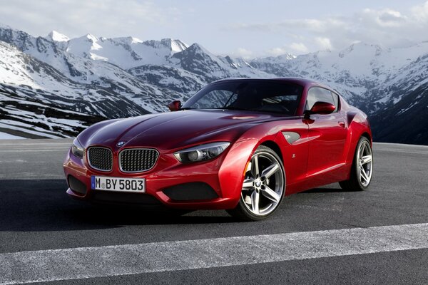 Bmw rouge se dresse sur fond de montagnes