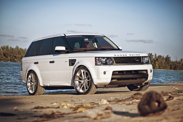 Белый спортивный range rover на пляже