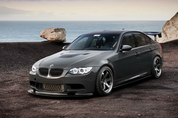 Stylish black bmw 3 series 335i e90 on the background of the sea