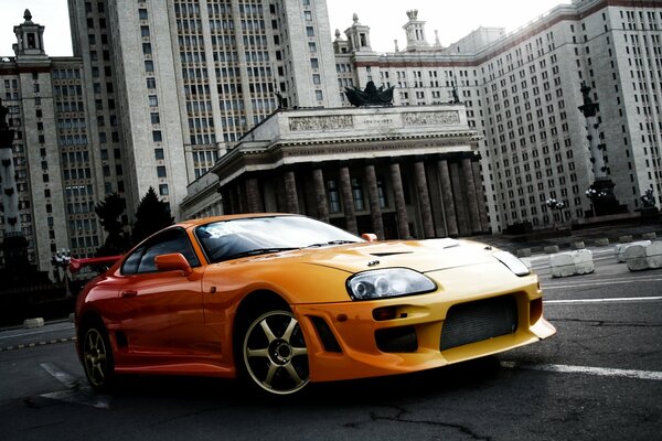 Toyota sports car orange on the background of the MSU building