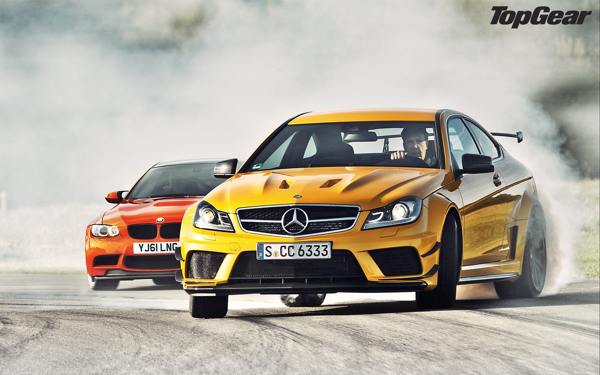 top gear top gear najwyższy bieg najlepszy program telewizyjny mercedes-benz c63 amg soire black series i bmw m3 gts mercedes c63 amg black siries bmw gts żółty pomarańczowy supersamochód przód poślizg drift dym