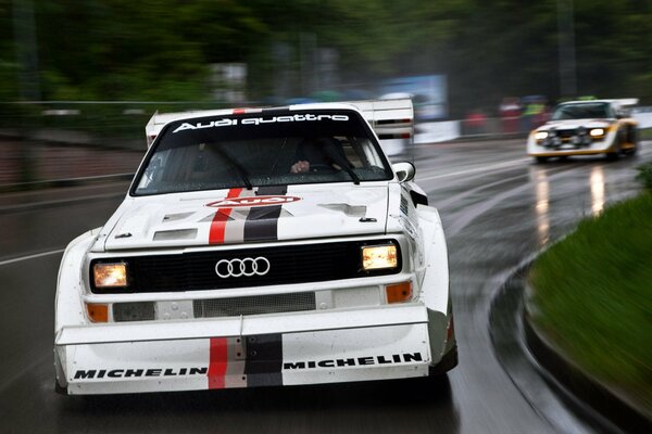 Audi blanc en mouvement sur route mouillée