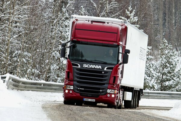 Camion rouge Scania sur piste enneigée