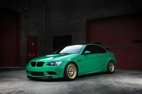 Green car in a brick garage