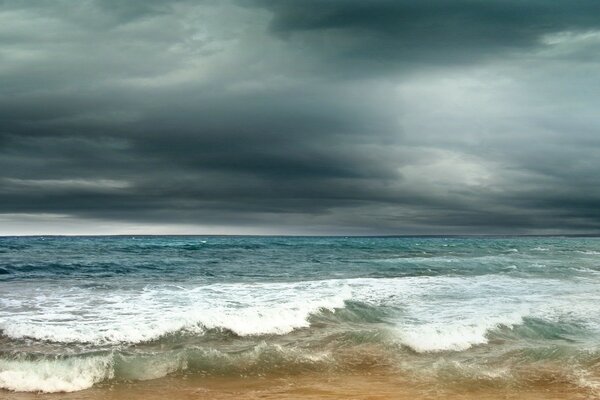 La mer éclaboussant les vagues sur le sable dans un orage