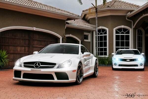 Weiße Mercedes und Chevrolet auf dem Hintergrund des Hauses