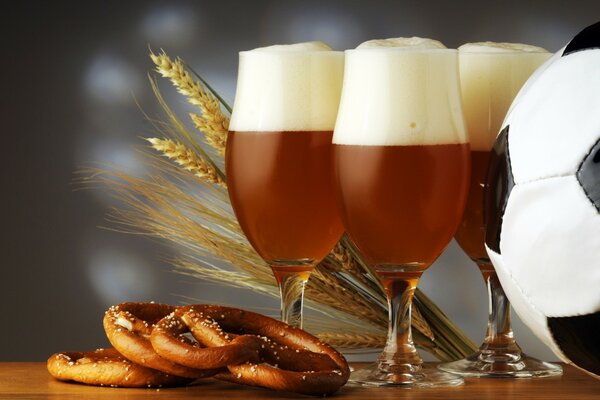 Nature morte sur le thème du football avec de la bière, des bretzels salés et un ballon noir et blanc